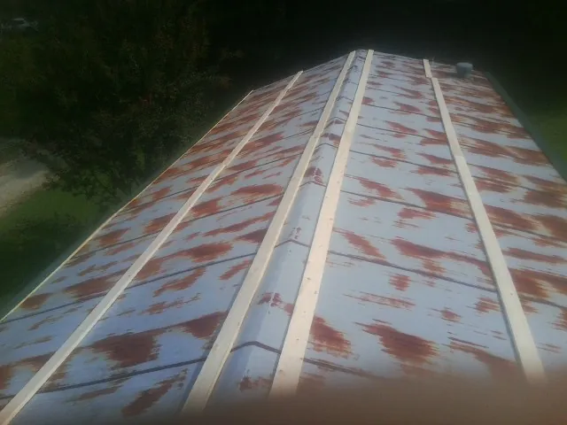 Rusted metal roof panels with new wood purlins before replacement — Storm Damage Roof Repair in Dannemora by Roofing Brothers