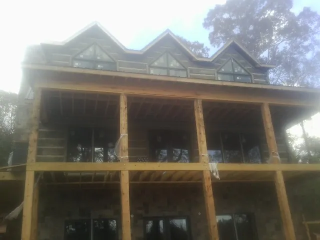 Dormers and porch framing on a large log home under construction — Roof Coating work by our crew in Dannemora
